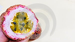 A person is holding a passion fruit with a lot of seeds in it