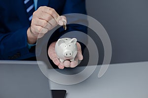 A person is holding a piggy bank, saving money and managing personal finances. Concept of increasing savings and savings by