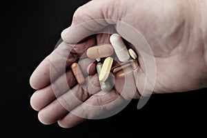 Person holding pills in his hand.