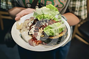 Person holding a plate of healthy food menu with fruits and vegetables