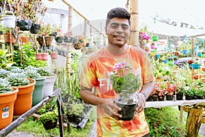 person holding pot with flower in flower shop photo