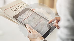 Person holding and reading news from tablet