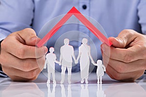 Person Holding Roof Over Family Paper Cut Out