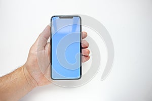 A person holding a Smart Phone with a blue sky screen on a white background