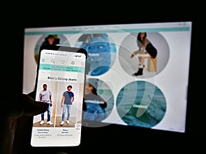 Person holding smartphone with website and logo of US retail company American Eagle Outfitters Inc. on screen.
