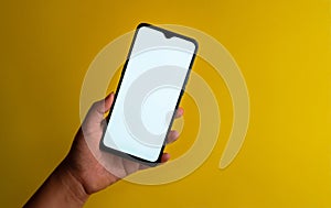 Person holding a smartphone  on a yellow background