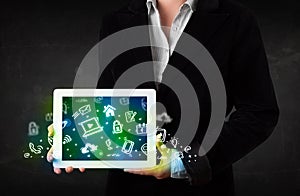 Person holding tablet with green media icons and symbols