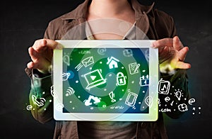 Person holding tablet with green media icons and symbols