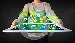 Person holding tablet with green media icons and symbols