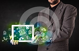 Person holding tablet with green media icons and symbols