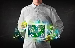 Person holding tablet with green media icons and symbols