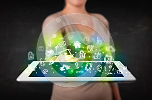 Person holding tablet with green media icons and symbols