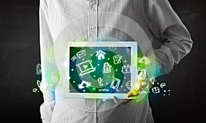 Person holding tablet with green media icons and symbols