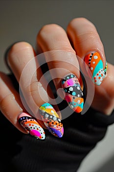 A person holding up colorful nail art with dots