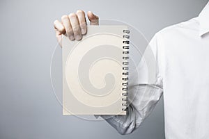 Person holding a vertical notebook.