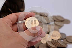 A person holding a 500 yen coin