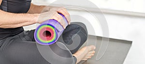 Person holding yoga mat at knee. Sport equipment concept