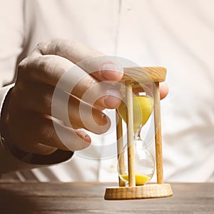 The person holds an hourglass in his hands. Business management. Logistics, process efficiency, savings. Time management photo