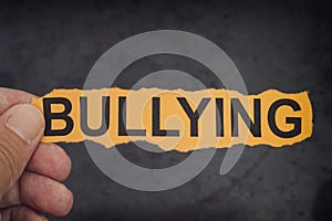 Person holds piece of paper with word Bullying in his hand