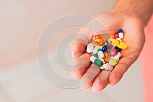 A person holds several medicine pills in his hand