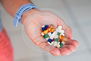 A person holds several medicine pills in his hand