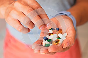 A person holds several medicine pills in his hand