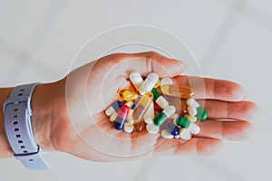 A person holds several medicine pills in his hand