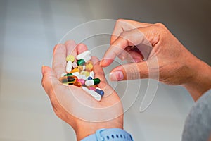 A person holds several medicine pills in his hand