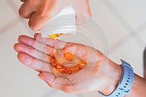 A person holds several medicine pills in his hand