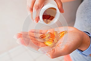 A person holds several medicine pills in his hand