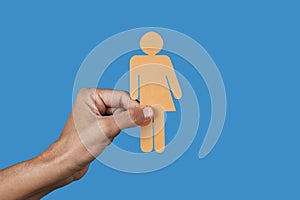 person holds a yellow gender neutral icon