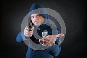 A person in a hoodie is aiming and holding the other hand.