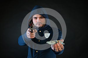 A person in a hoodie is aiming and holding the other hand with the dollar note.