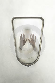 Person imprisoned in a mirror, concept of identity crisis photo