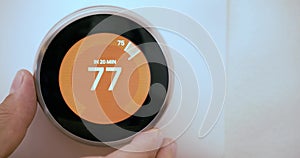 A person increasing the temperature on a Smart Thermostat on fahrenheit scale