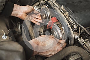 A person independently changes the timing belt in a passenger car