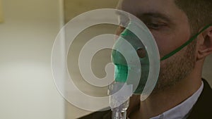 A person inhales through an inhaler mask