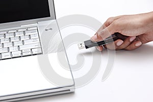 Person inserting a usb drive into a laptop photo