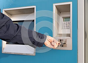 Person inserts payment card into a self service ticket machine