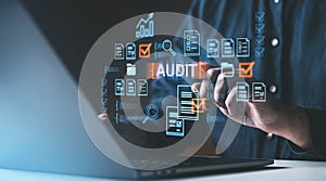 Person interacts with digital audit interface, features checklists and documents, on a tech-themed background, concept of quality photo