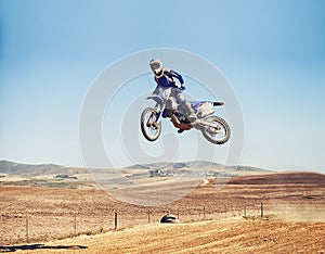 Person, jump and dirt bike of professional motorcyclist in the air for trick, stunt or race on outdoor track. Expert