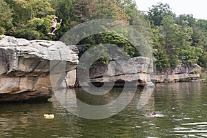 Person Jumping from Cliff into Lake