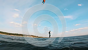 Person jumps while riding a kiteboard.