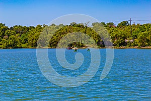 Person in a Kayak with an umbrella on a sunny day on the lake