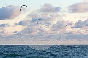 Person kitesurfing at dawn