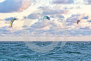 Person kitesurfing at dawn