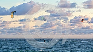 Person kitesurfing at dawn