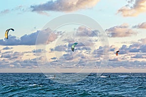 Person kitesurfing at dawn