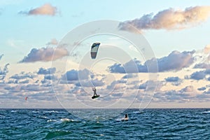 Person kitesurfing at dawn