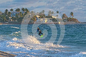 Person kitesurfing at dawn